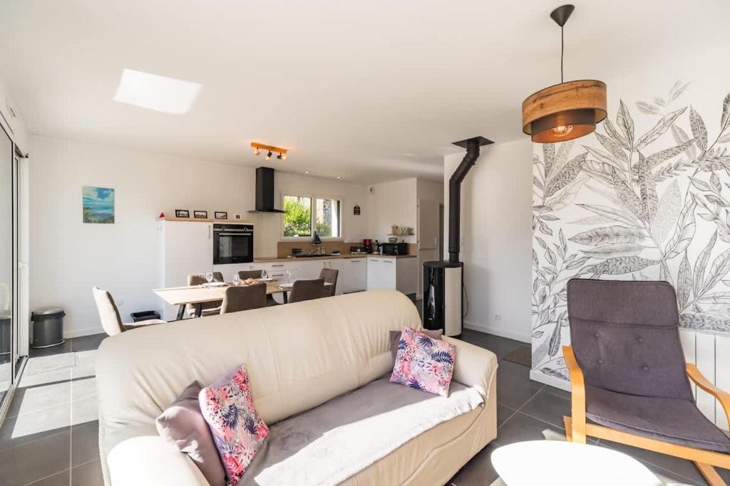 un soggiorno con divano e cucina di Ty Menez - Maison neuve proche commerces et plages a Pordic