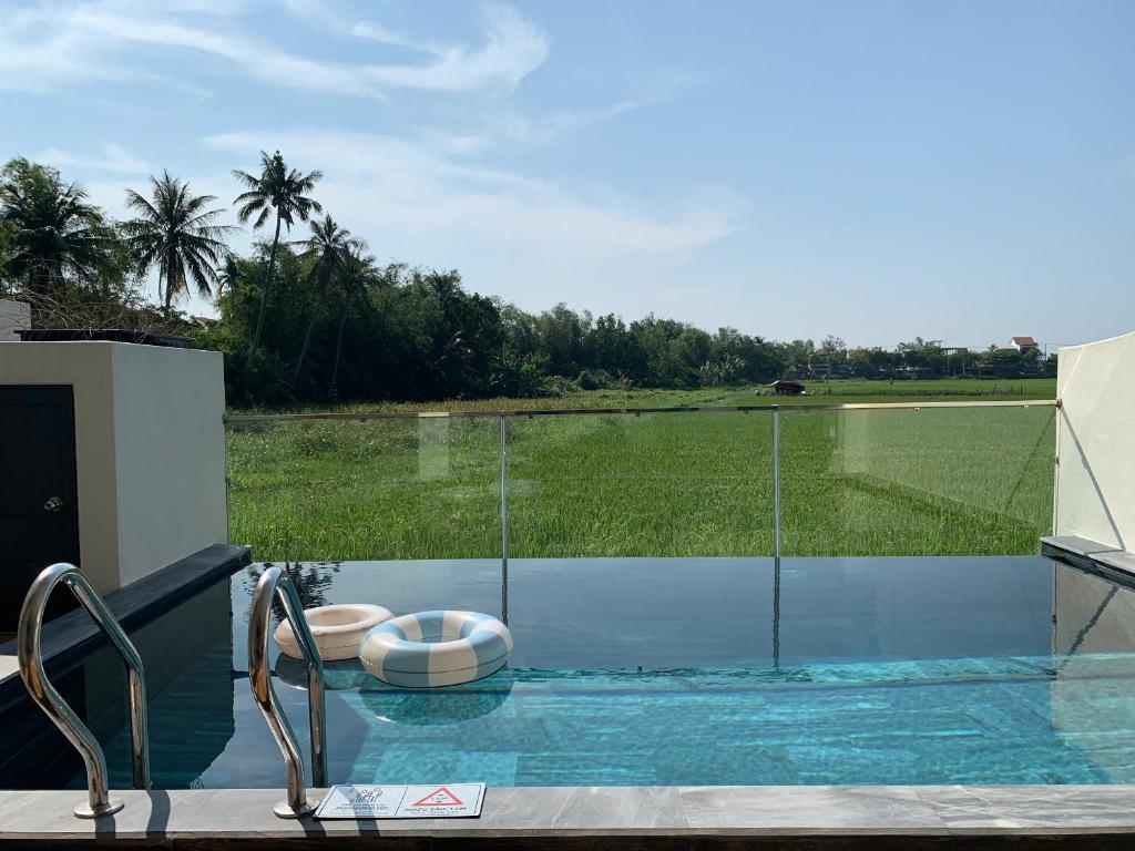 a swimming pool with a view of a golf course at AN'Lavie Private Pool Villa in An Bang