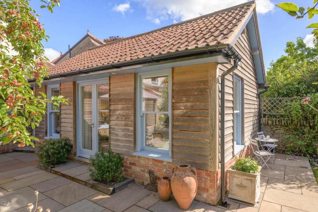 a small house with windows on a patio at The Artists Studio Private Parking Frome in Frome