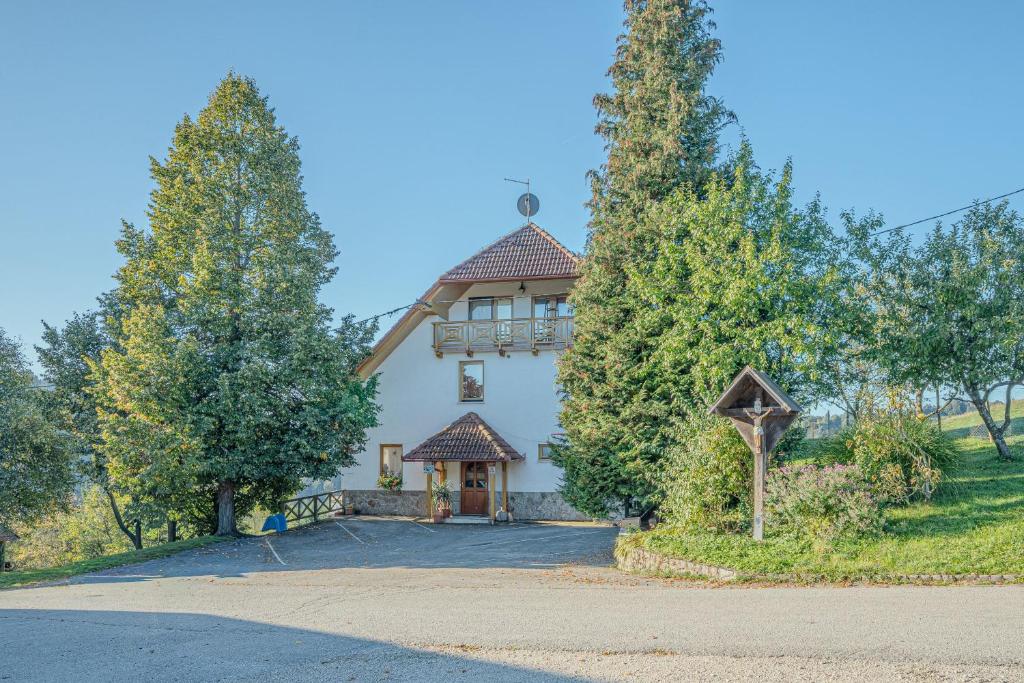 a large white house with trees in front of it at Oblak Estate Apartments in Ortnek