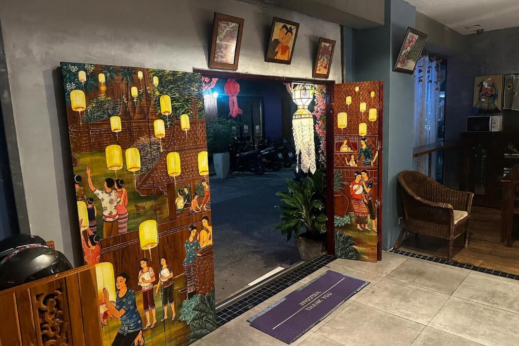 Una entrada a una habitación con una puerta con una pintura en ella. en SawasdeeCiao Patong Guesthouse, en Patong Beach