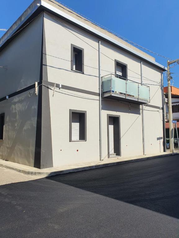 a white building with a balcony on the side of it at Residenza Santa Maria app Save in Nicotera Marina