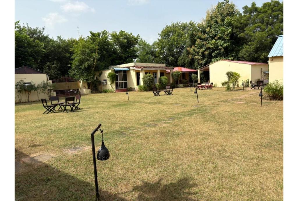 a group of picnic tables and benches in a yard at Shikaar Valley in Khilchipur