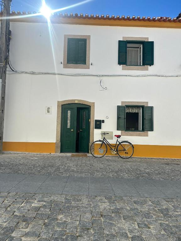 a bike parked in front of a building with a door at Casa de Alpalhão in Alpalhão