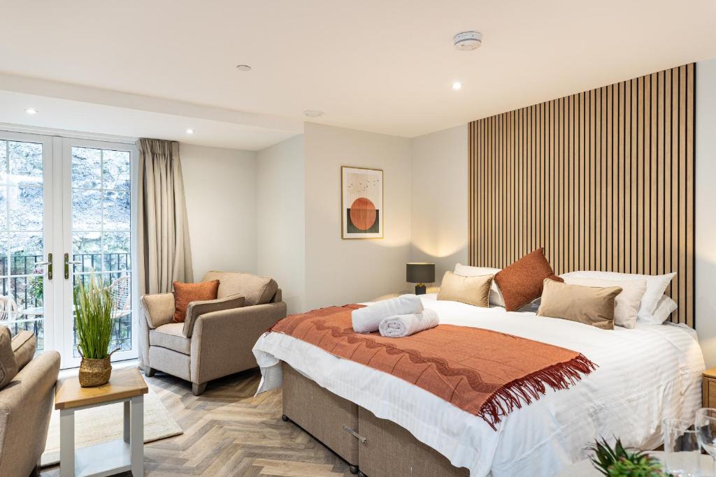 a bedroom with a bed and a couch and a chair at Rock Mill Studio Apartment 16 in Stoney Middleton