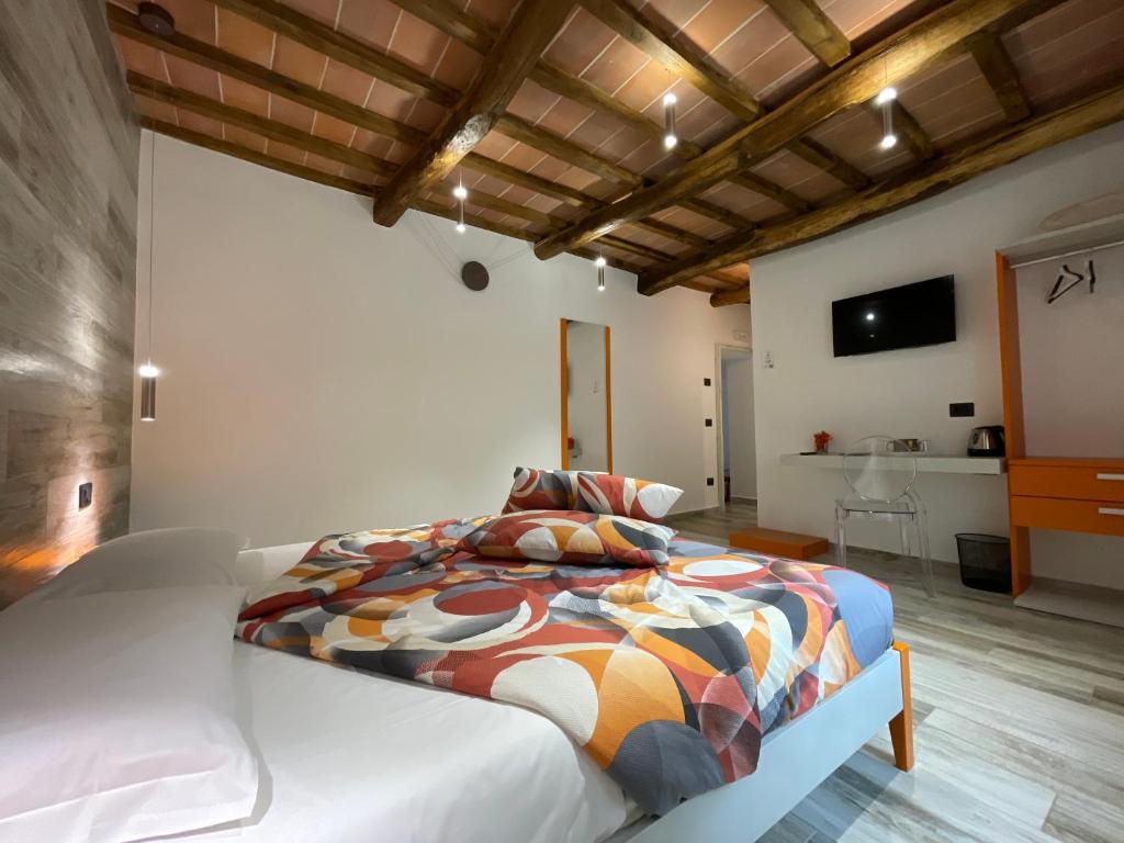 a bedroom with a bed with a colorful comforter at Il Gaudente B&B in Santa Fiora
