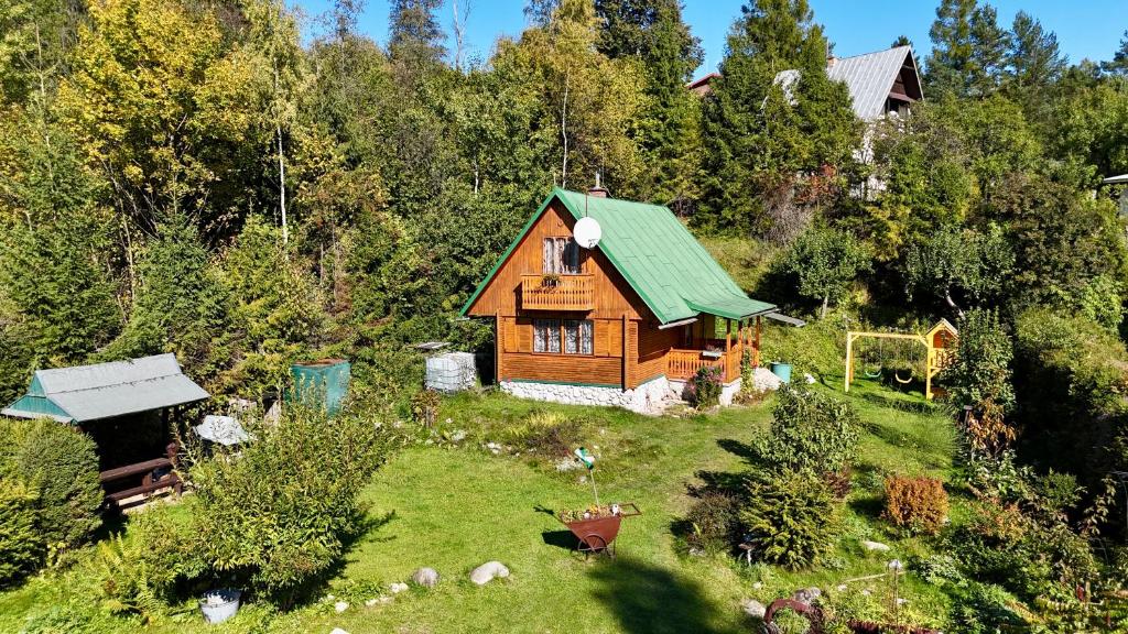una pequeña casa con techo verde en un campo en Chata Retro, en Stará Lesná