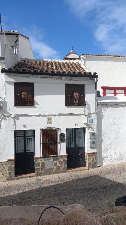a white building with black doors and windows at El Estudio Lila de Ubrique in Ubrique