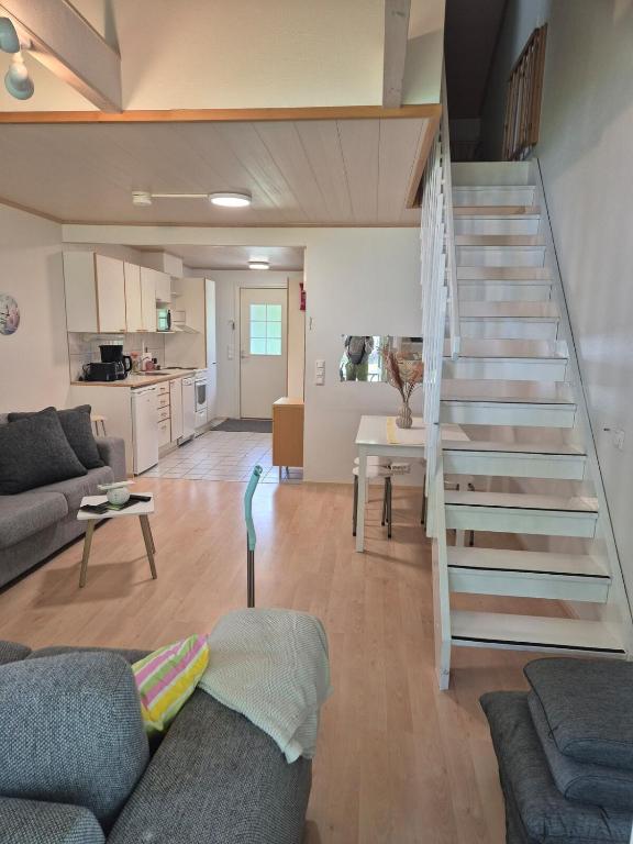 a living room with a couch and a staircase at Rauhallinen rivitalo in Kilvakkala