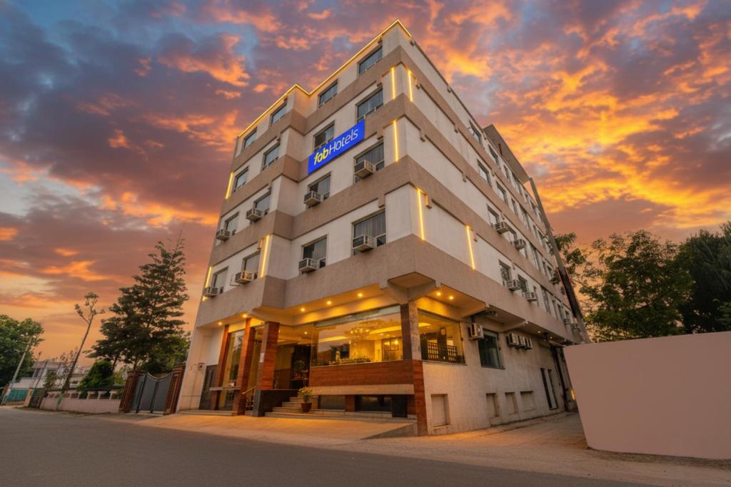 un edificio de hotel con una puesta de sol en el fondo en FabExpress HC Mount View, en Mohali