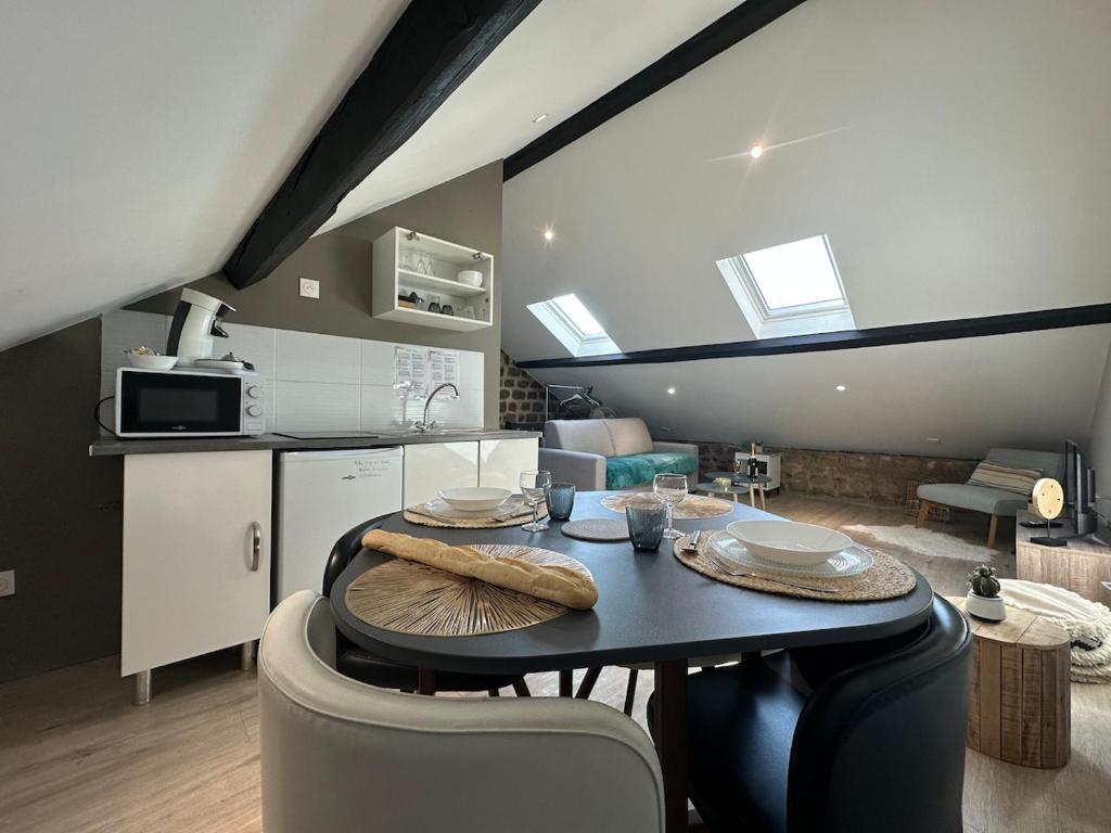 a kitchen with a table and chairs in a room at C Copenhague - charmant studio proche centre-ville in Charleville-Mézières