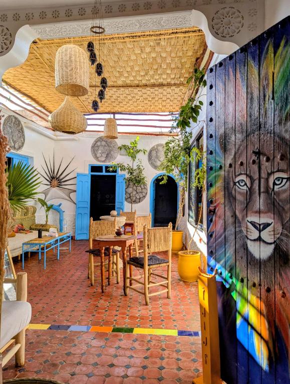 a dining room with a mural of a lion on the wall at Mandalahome in Marrakesh