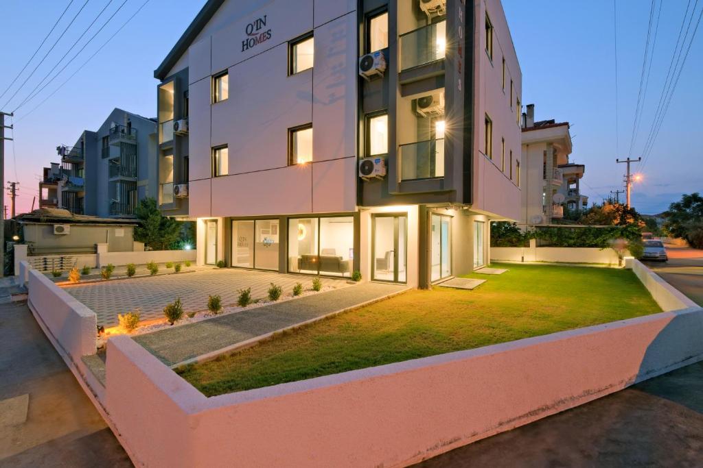 a large building with a lawn in front of it at Q'in HOMES in Fethiye