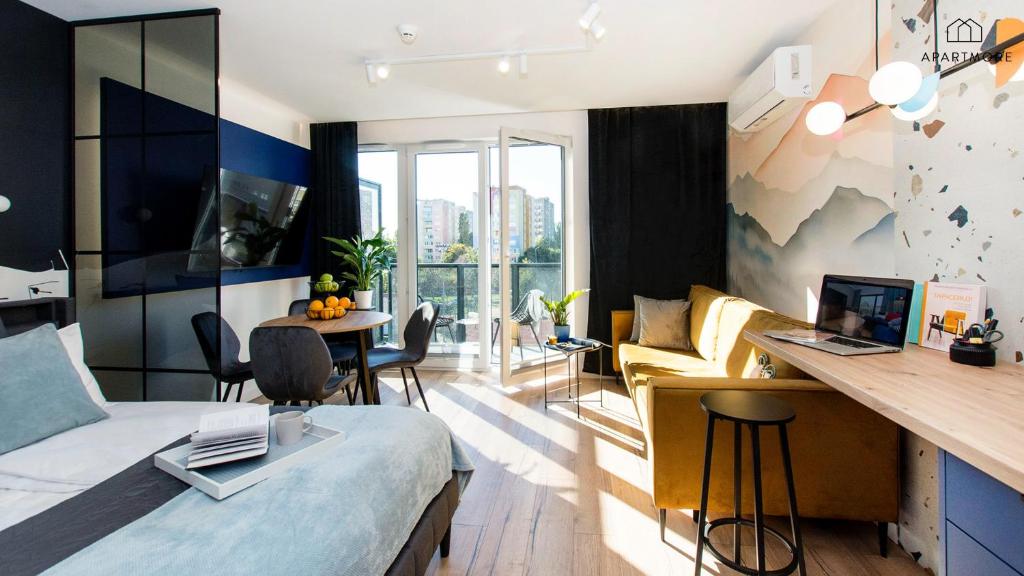 a room with a bed and a desk with a computer at Portovo Residence managed by Apartmore in Gdańsk