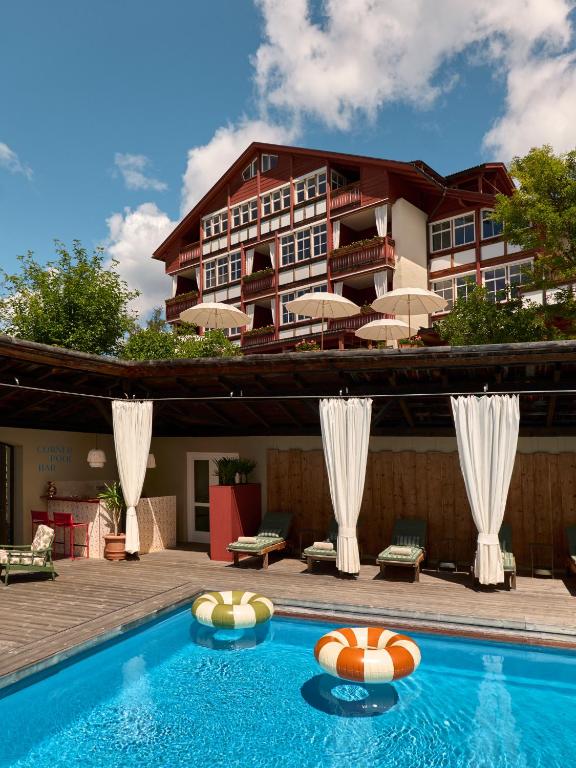 a hotel with a swimming pool in front of a building at Berghoferin Fine Hotel & Hideaway in Redagno