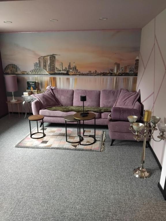 a living room with a purple couch and a table at Art Place Home in Rückersdorf