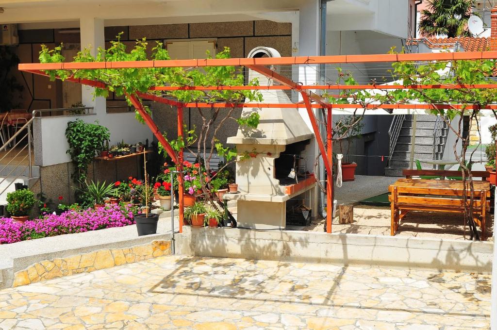 eine orangefarbene Struktur mit Pflanzen darauf in einem Garten in der Unterkunft Apartments Pako in Pakoštane