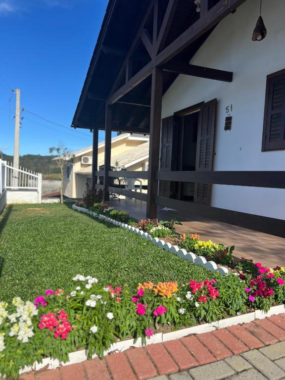 a garden of flowers in front of a building at Pousada Jardim in Lauro Müller