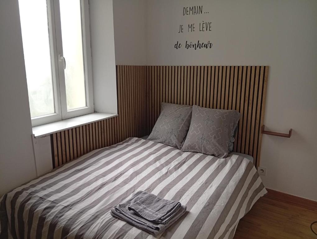 a bed with two towels on it in a bedroom at Aux portes de l'Eure in Bonnières-sur-Seine