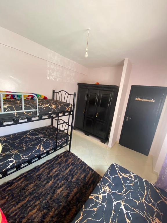 a bedroom with two bunk beds and a black cabinet at Appartement confortable et ensoleillée in Aïn Harrouda