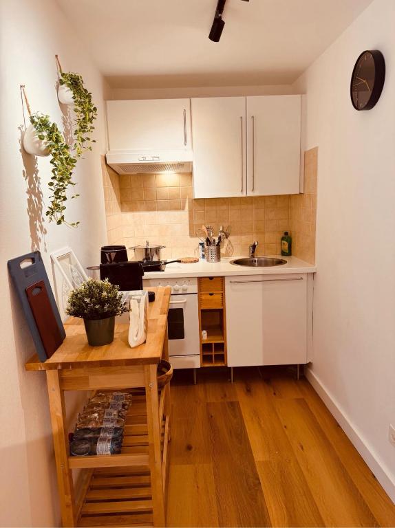 a kitchen with white cabinets and a wooden table at Foresta Living in Mendrisio