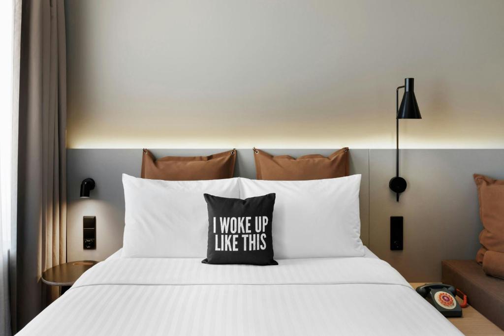 A close, symmetrical view of the made bed with integrated lighting and a small adjoining sofa.
