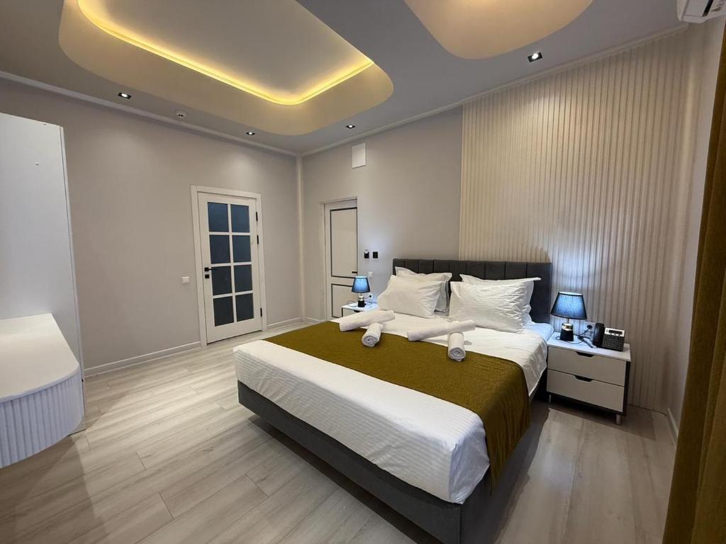 a bedroom with a large bed and a yellow ceiling at Turkezm Hotel in Urganch