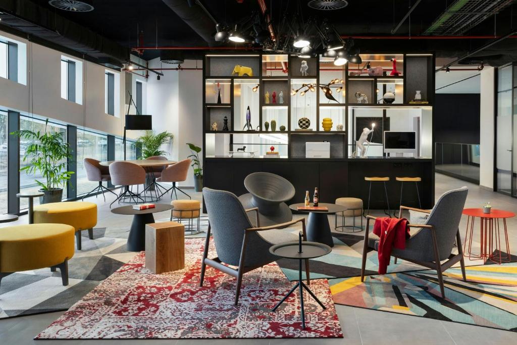A lively open lounge with mixed seating, communal work areas and colorful rugs.