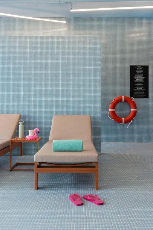 A tiled relaxation zone with chaise loungers and playful poolside props.