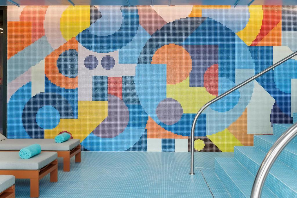 A colorful tiled relaxation area beside stairs and loungers.
