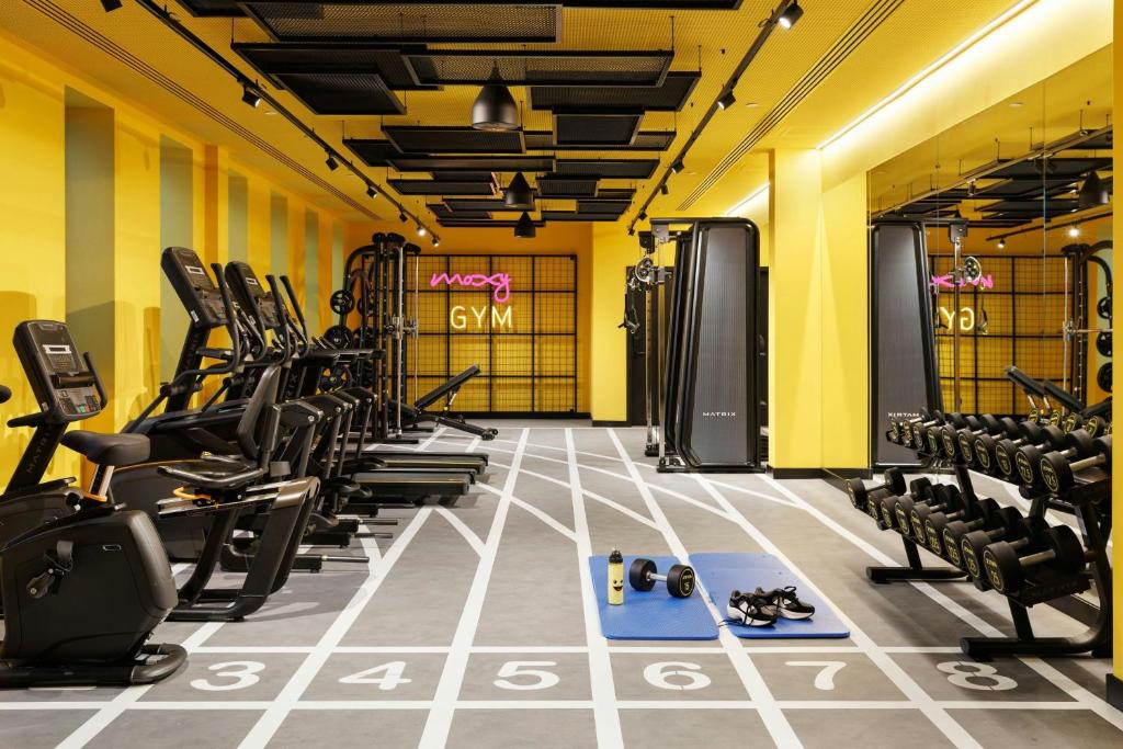 A long, fully equipped gym with cardio machines, weights and mirrored walls.