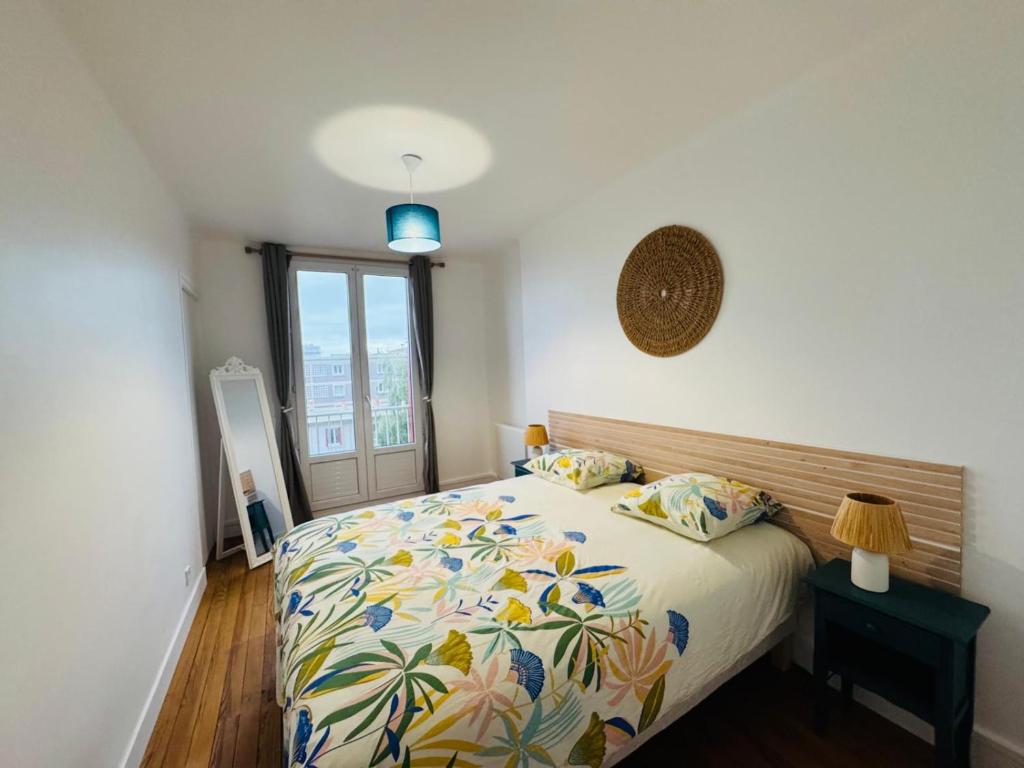 ein Schlafzimmer mit einem Bett mit geblümter Tagesdecke in der Unterkunft Le Perret -Centre -Authentique -UNESCO in Le Havre