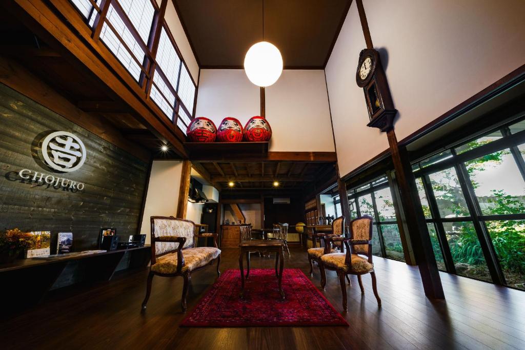 a restaurant with a table and chairs and a clock at ワイナリーや酒蔵巡りなどにおすすめの宿 小諸市 築100年の古民家 Chojuro -長寿楼- in Komoro