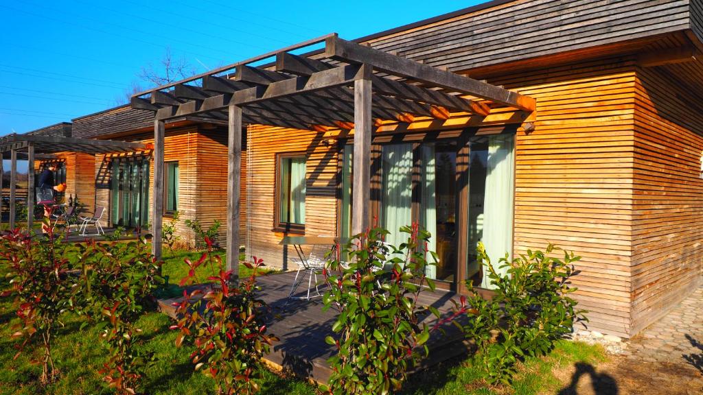 a wooden house with a pergola on it at Zagreb Camp Bungalows in Rakitje