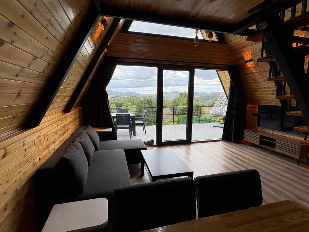 een woonkamer met een bank en een groot raam bij Paradise bungalov in Kocaeli