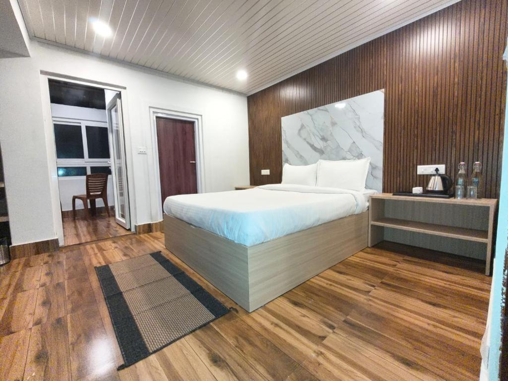 a bedroom with a large bed and a table and chair at Pineview Escapes in Jālāpahār