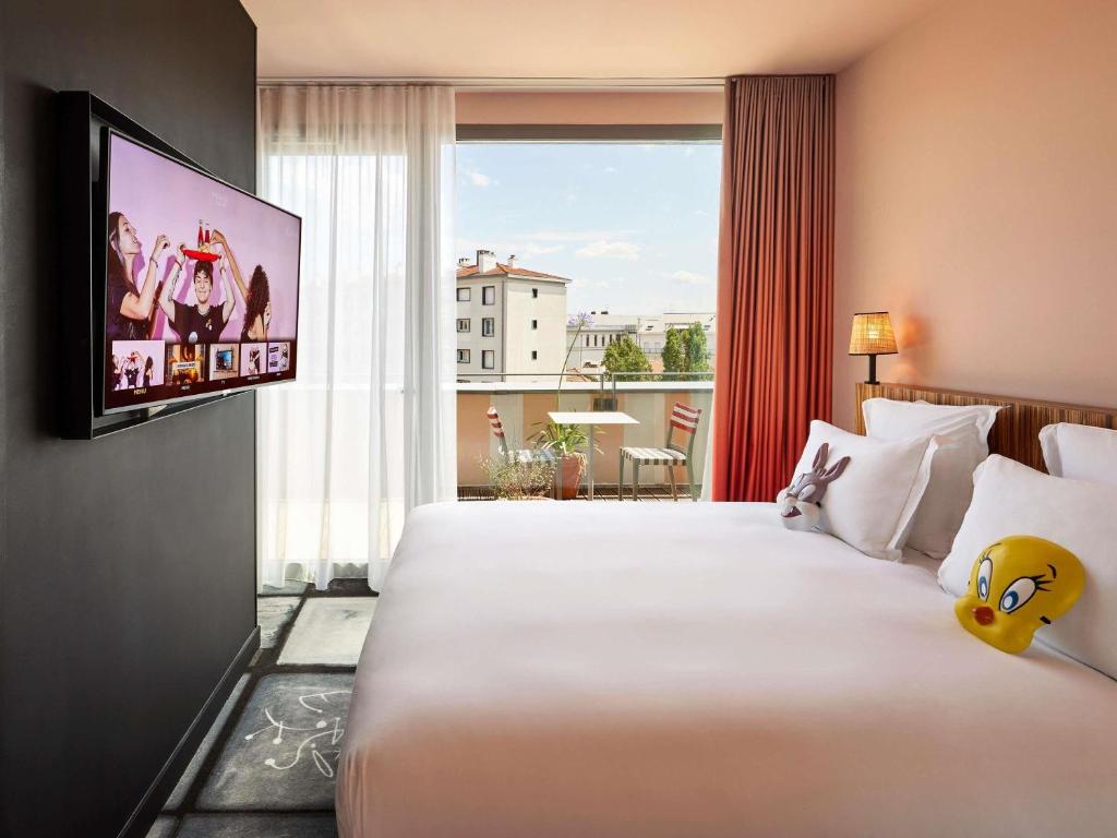 a hotel room with a large bed and a tv at Mama Shelter Lyon in Lyon