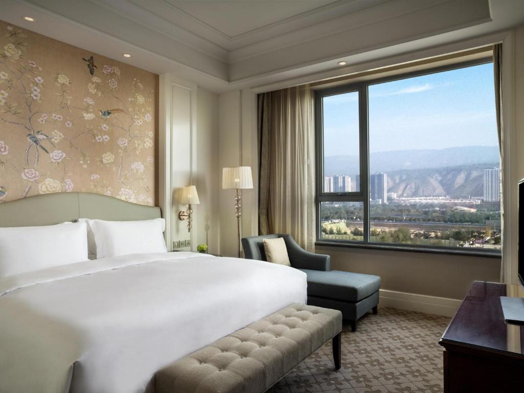 a hotel room with a bed and a window at Sofitel Xining in Xining