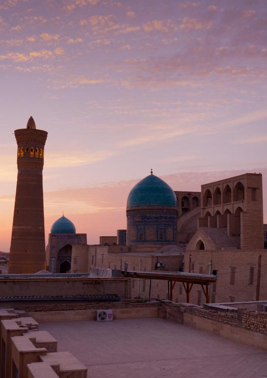 una mezquita con un minarete y una torre de reloj en Omar Khayyam Hotel, en Bukhara