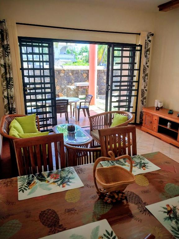 a living room with a table and chairs and a glass door at SéjourdétenteàMaurice in Albion