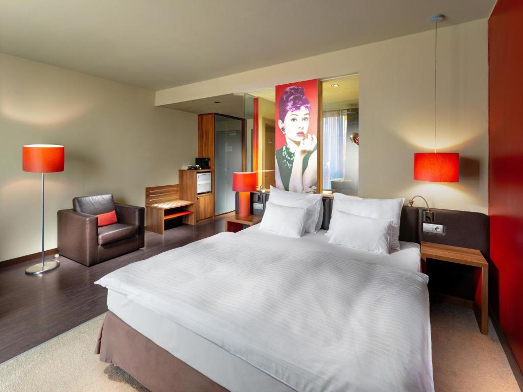 a bedroom with a large white bed and a chair at Clarion Congress Hotel Bratislava in Bratislava