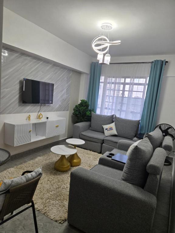 a living room with a couch and a tv at Hami Ventures in Kisumu