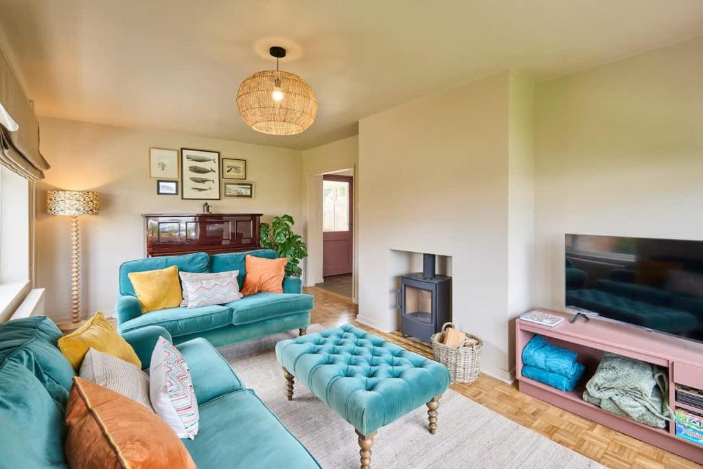 a living room with blue couches and a tv at The Beach House in Overstrand