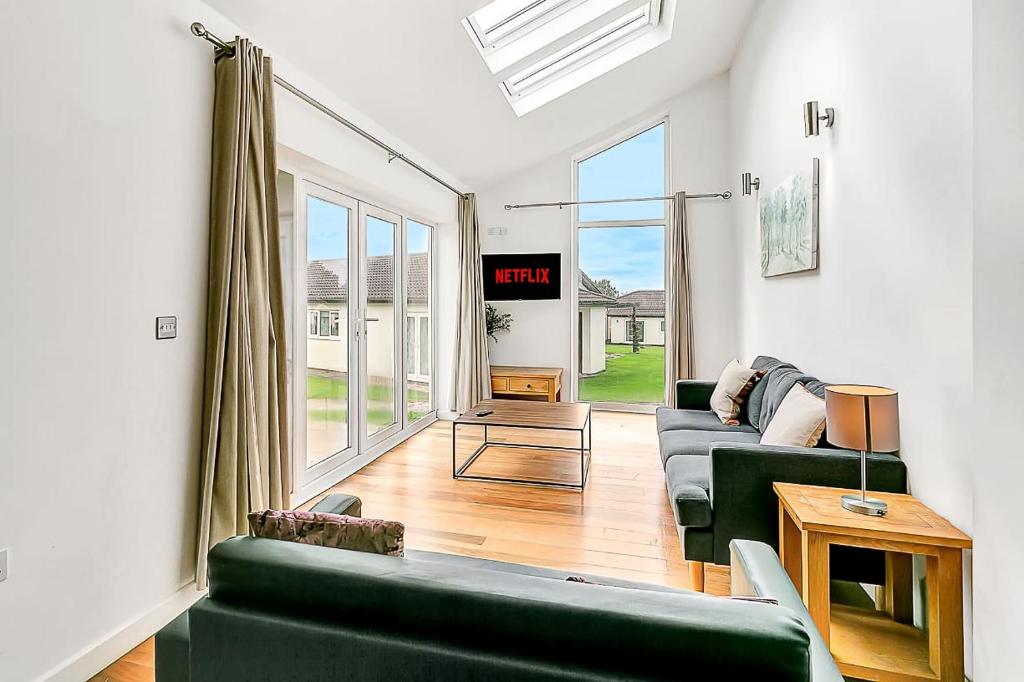 a living room with a green couch and a tv at Lovely 2 Bedroom Holiday Chalet near Sidmouth in Sidmouth