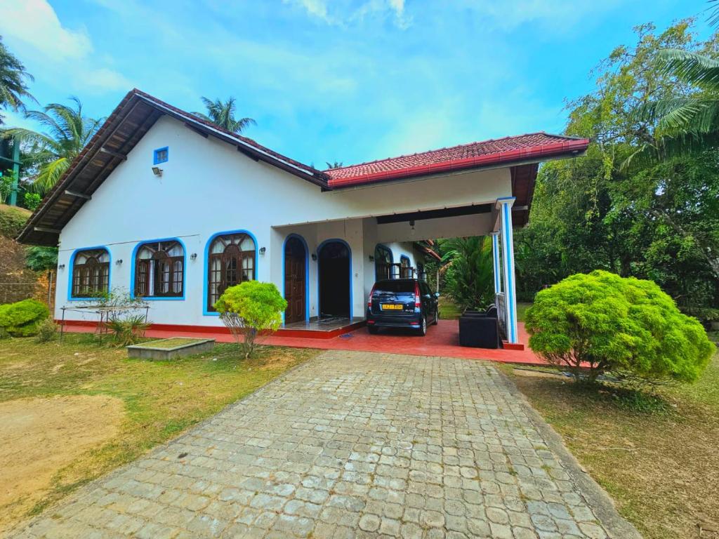 a house with a car parked in the driveway at Kurundu House Mirissa in Mirissa