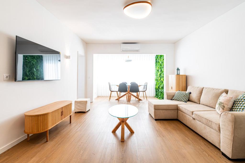 een woonkamer met een bank en een tafel bij Charming Estoril Apt One Min Walk to the Beach in Estoril