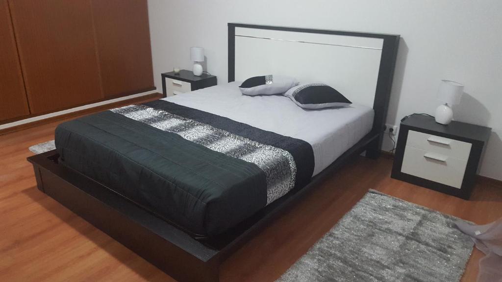 1 dormitorio con 1 cama grande y 2 mesitas de noche en Apartamento Moderno e Elegante, en Ponta Delgada