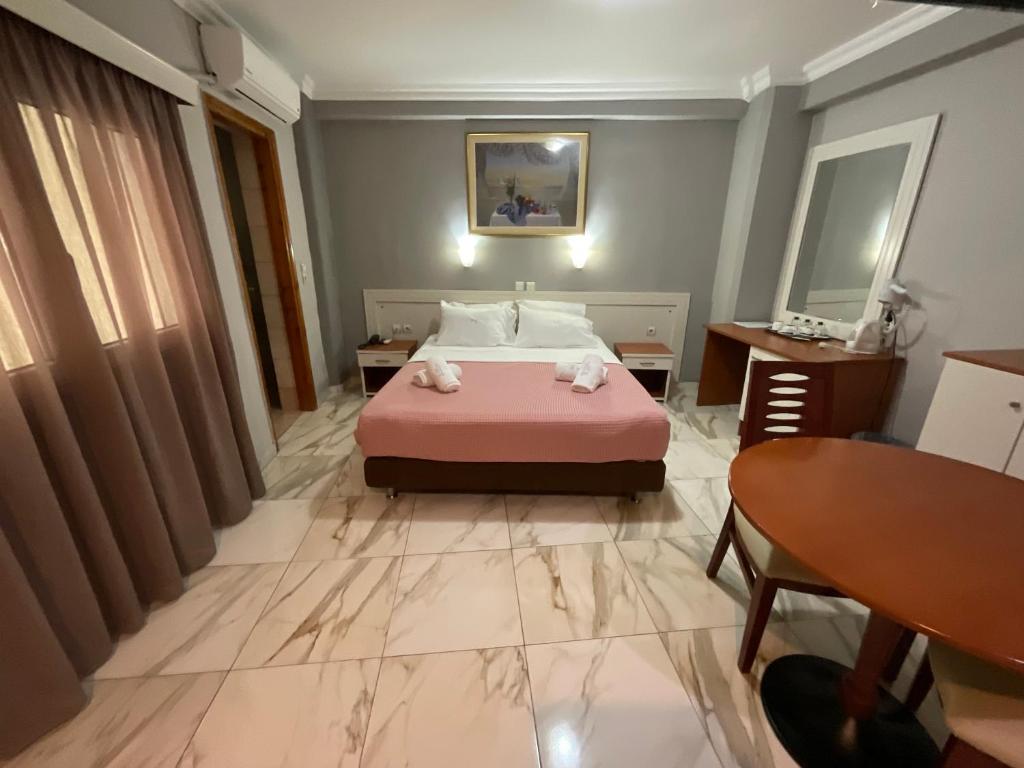 a bedroom with a pink bed and a table and a desk at Piraeus Acropole Hotel in Piraeus