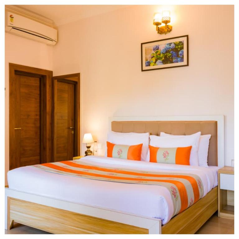 een slaapkamer met een groot bed met oranje en witte kussens bij Sanskari Nivas family holiday home in Kasauli