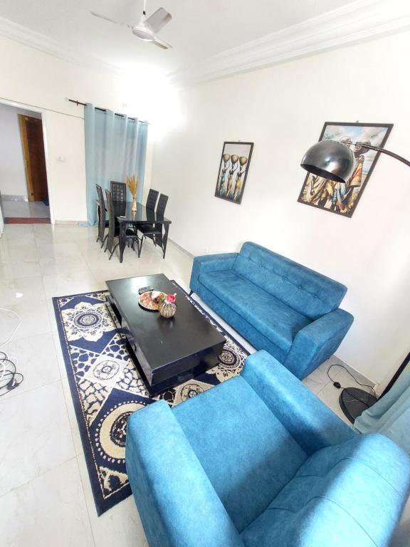 a living room with blue couches and a table at Horizon Sûr in Dakar